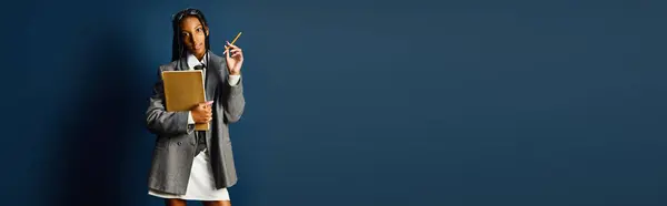 Young woman holds folders and a pen, poised for a discussion in a stylish setting. — Stock Photo