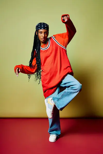 A young woman showcases her fashion sense with confidence, standing on one leg in a trendy outfit. — Stock Photo
