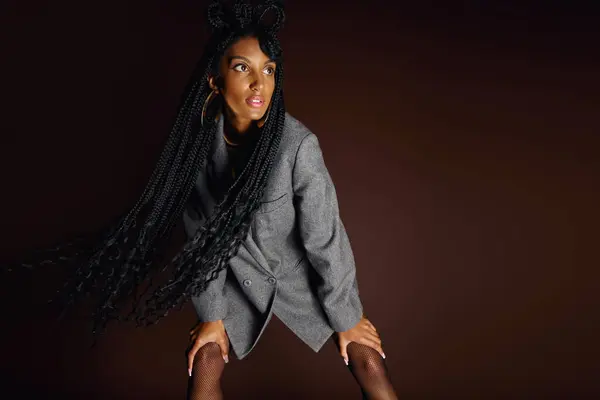 Confident young woman showcases a unique fashion sense with striking long hair and a blazer — Stock Photo