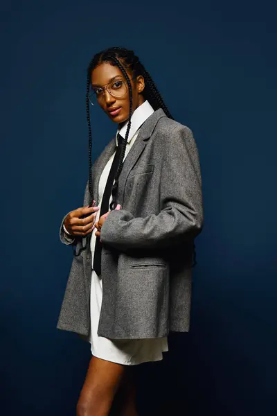 Mujer joven con confianza muestra su estilo en una chaqueta elegante y corbata. - foto de stock