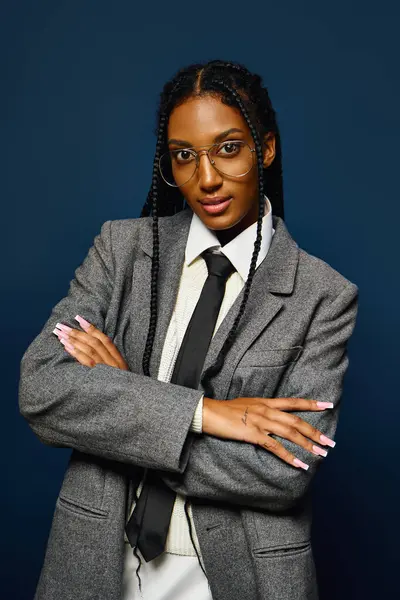 A confident young woman poses with crossed arms in stylish professional attire. — Stock Photo