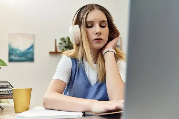 Teenage girl immersed in her studies while listening to music in her stylish bedroom. — Stock Photo