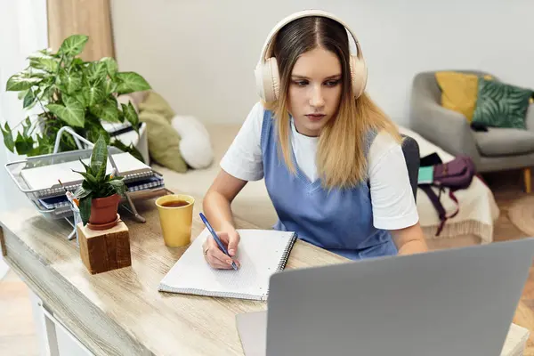 Giovane ragazza si concentra sui suoi studi, mentre circondato da un accogliente, spazio di vita contemporanea. — Foto stock