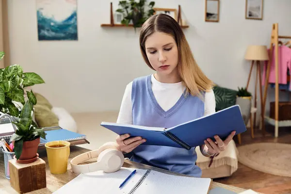 A teenager immersed in her studies at home, surrounded by plants and a vibrant atmosphere. — Stock Photo