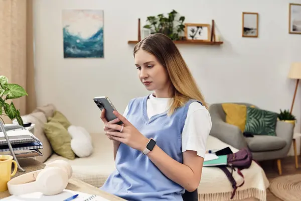 A pretty teenage girl sits in her stylish room, focused on her phone while relaxing. — Stock Photo