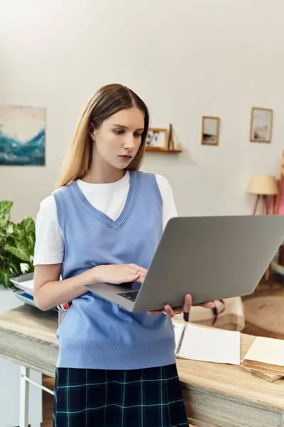 A teenage girl engages with her laptop in a stylish, modern room filled with personal touches. — Stock Photo