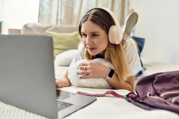Uma adolescente desfruta de seu tempo em um laptop em um ambiente doméstico confortável, abraçando a cultura juvenil. — Fotografia de Stock