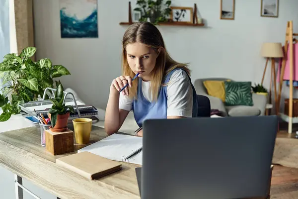 Focused girl reflects on her studies while sitting at a stylish desk in her room, deep in thought. — Stock Photo