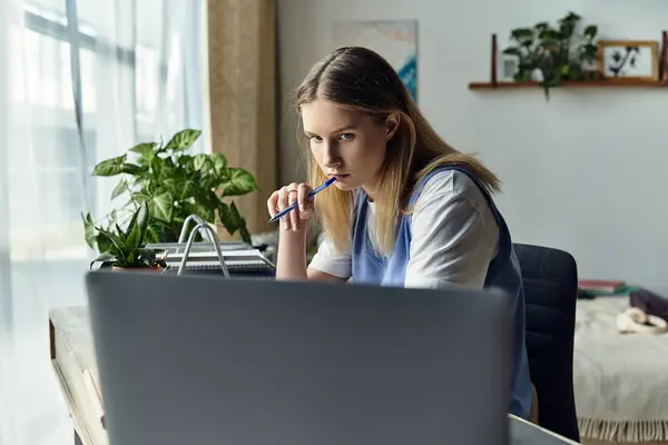 A young girl thoughtfully engages with her studies, surrounded by her cozy home environment. — Stock Photo