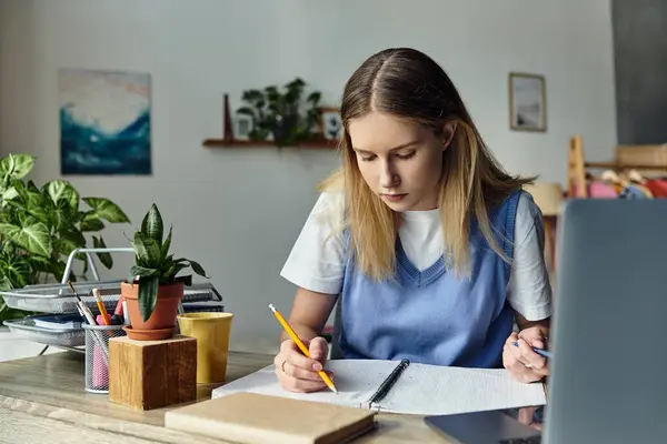 A teenage girl focuses on her studies while surrounded by personal touches in her cozy room. — Stock Photo