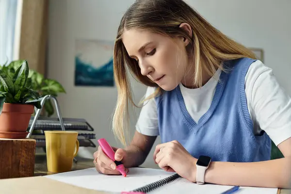 A pretty teenage girl focuses intently on her studies, surrounded by her vibrant room decor. — Stock Photo