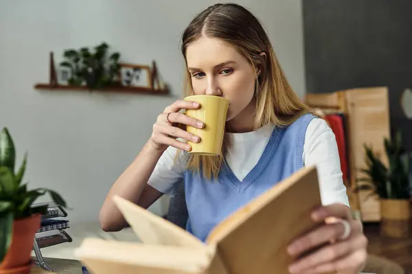 A teenage girl enjoys her time reading while sipping a warm beverage in her stylish room. — Stock Photo