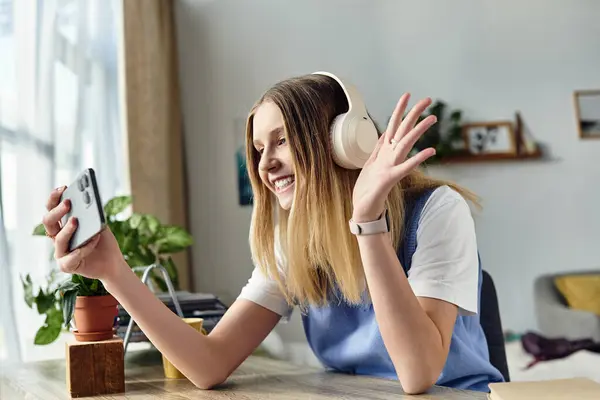 A teenage girl in her stylish room happily enjoys a video call while listening to music. — Stock Photo