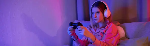 Una ragazza adolescente gode di una sessione di gioco nella sua accogliente, moderna stanza piena di luce serale, banner — Foto stock