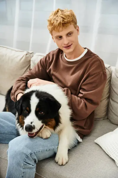 Young man enjoys quality time with his Australian Shepherd in a cozy apartment. — Stock Photo