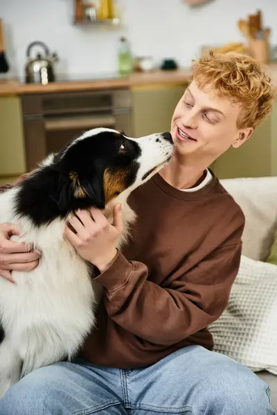A young redhead shares playful moments with his adorable Australian Shepherd in a modern apartment. — Stock Photo
