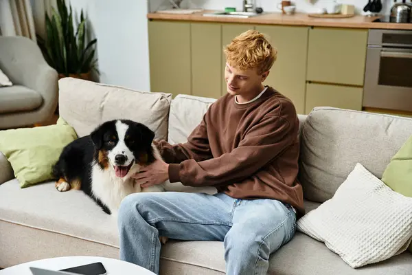 Espace de vie moderne rempli de chaleur alors que le jeune homme interagit avec son chien amical. — Photo de stock