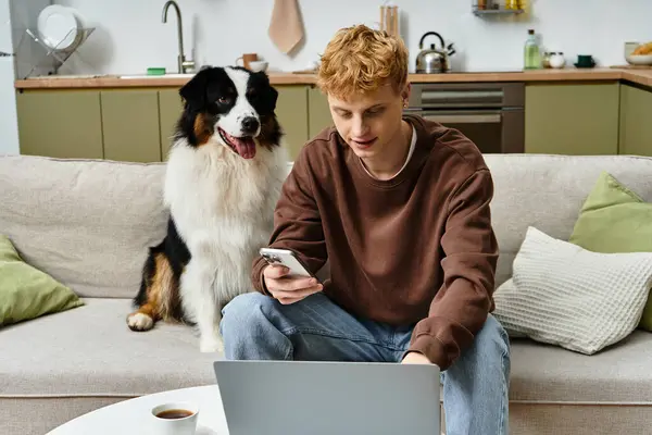 Charming young man interacts with his adorable Australian Shepherd in a cozy home setting. — Stock Photo