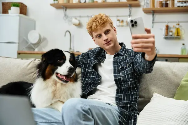Young man enjoys quality time with his Australian Shepherd dog, capturing fun memories at home. — Stock Photo