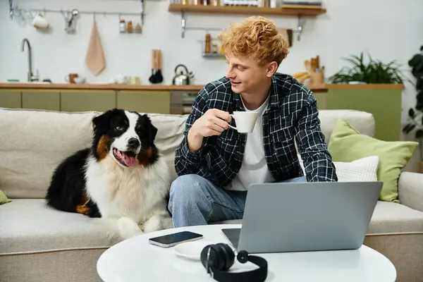 Young man shares a peaceful moment with his dog while sipping coffee in a stylish home. — Stock Photo