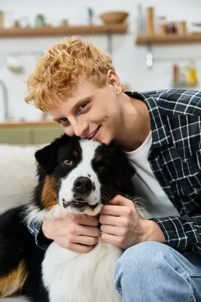 Young redhead man enjoys quality time with his adorable Australian Shepherd in a modern apartment. — Stock Photo