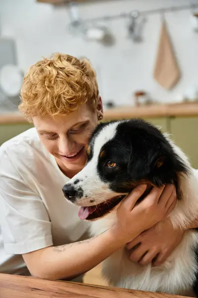 A cheerful man with red hair enjoys heartwarming moments with his Australian Shepherd at home. — Stock Photo