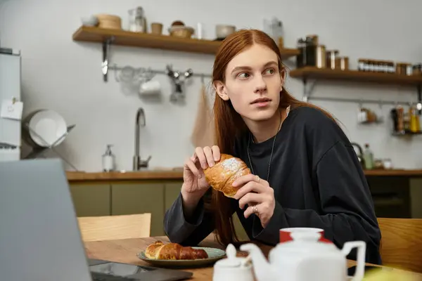 Casual morning vibes fill the air as a young man savors a delicious pastry at home. — Stock Photo