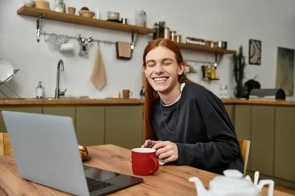 Bright smile of a young man enjoying his coffee while relaxing at home. — Stock Photo
