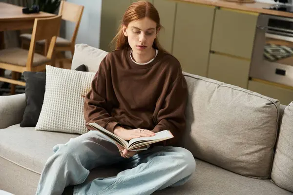 Casual moment in a modern apartment as a redhead guy reads in a comfortable sweater. — Stock Photo