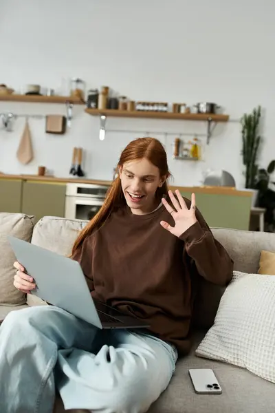 Young man in casual attire enjoys a video call from his stylish, relaxed living space. — Stock Photo
