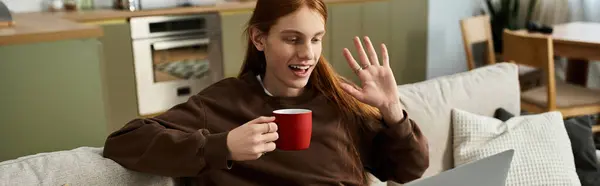 A charming young man with long red hair enjoys a warm beverage while smiling and waving, banner — Stock Photo