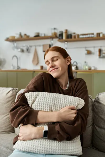 A young man with long red hair relaxes on a pillow in a stylish apartment. — Stock Photo