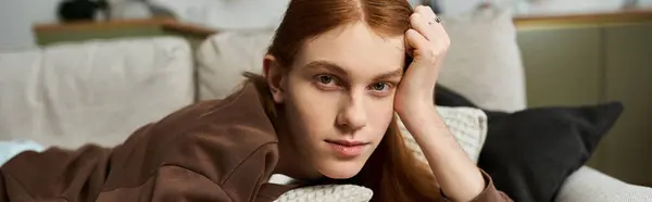 Un beau jeune homme aux longs cheveux roux profite d'un moment de détente dans son appartement élégant, bannière — Photo de stock