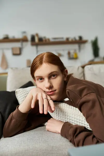 A young man with long red hair relaxes in his stylish, cozy apartment. — Stock Photo