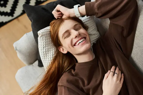 A cheerful young guy lounges comfortably in his home, showcasing a carefree lifestyle. — Stock Photo