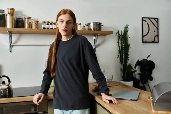 A young man with long red hair relaxes in his stylish apartment, enjoying a cozy moment. — Stock Photo