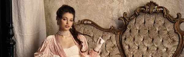 A lovely young woman in a nymph outfit rests gracefully on vintage furniture, radiating charm. — Stock Photo