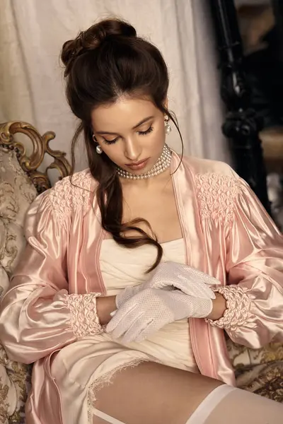 A young woman in a vintage outfit sits gracefully, lost in thought, surrounded by an ethereal glow. — Stock Photo
