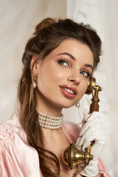 Mystical young woman adorned in vintage fashion engages with an old fashioned telephone. — Stock Photo