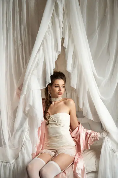 A young woman embodies a mystical nymph, draped in elegant fabrics with a dreamy aura. — Stock Photo