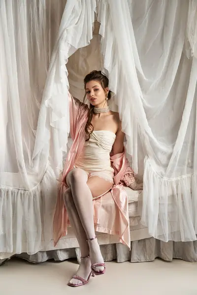 A young woman embodies fantasy and beauty, adorned in delicate fabrics within a dreamy atmosphere. — Stock Photo