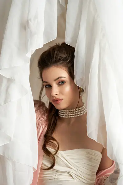 A young woman embodies a mystical nymph amidst soft, flowing fabrics, radiating beauty and wonder. — Stock Photo