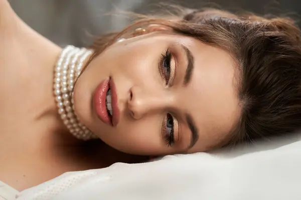 A young woman with enchanting features relaxes gracefully in a serene, ethereal atmosphere. — Stock Photo