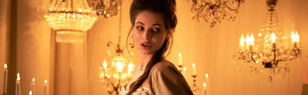 Uma jovem mulher com uma presença sedutora exala mistério em um cenário elegante, candelabro. — Fotografia de Stock