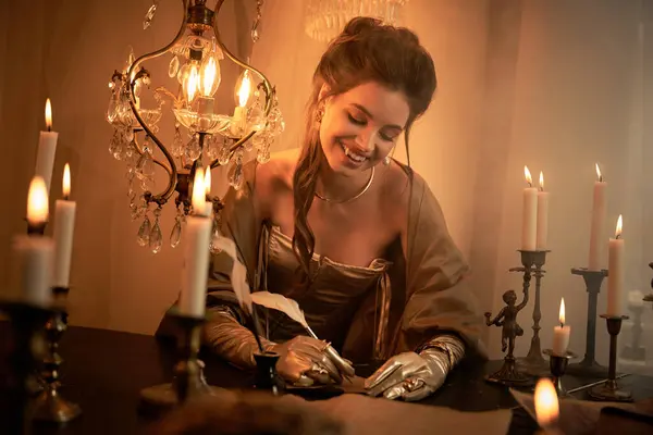 A young woman, a beautiful vampire, crafts letters in an enchanting room illuminated by candles. — Stock Photo