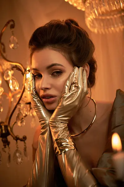 A young woman embodies an elegant, mystical vampire in golden gloves and perfect light. — Stock Photo
