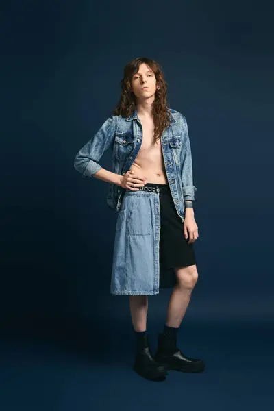 Ein stilvoller junger Mann trägt selbstbewusst trendige Jeans und zeigt seinen einzigartigen Sinn für Mode. — Stockfoto