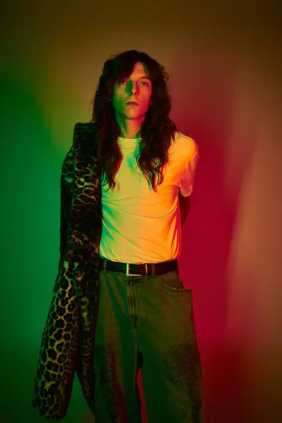 A young man displays his trendy outfit in a colorful, captivating atmosphere that draws attention. — Stock Photo