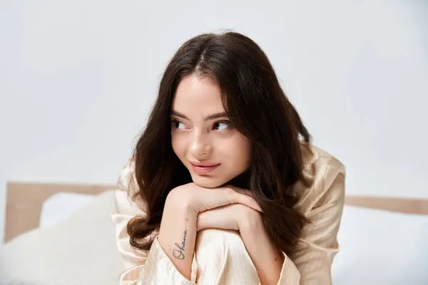 A beautiful young woman rests her chin on her hands, radiating calmness and charm in a cozy setting. — Stock Photo