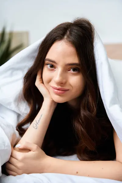 Bright sunlight filters through the room as a lovely young woman relaxes, smiling warmly. — Stock Photo